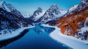 Serene Winter Landscape Frozen Lake Surrounded by Snow Capped Mountains and Autumnal Trees photo