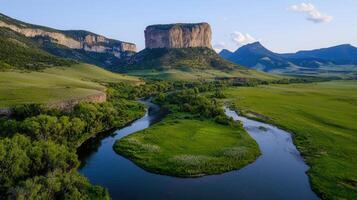 Scenic Aerial View of River Winding Through Lush Green Valley and Majestic Rock Formations photo