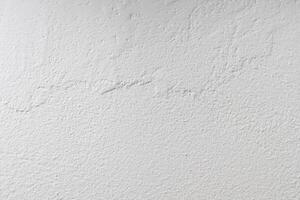 The wall is painted with white paint with a visible texture photo