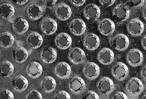 Background or texture from a gray and monophonic metal surface with symmetric and round openings. photo