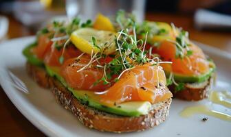 A plate of bread with avocado and salmon on top photo