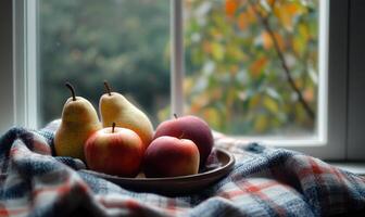 A plate of apples and pears on a blanket photo