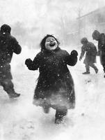 Joyful plus-size child laughing while playing in deep snow on a winter day with friends in a playful atmosphere photo