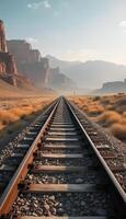 A railroad track in the desert with mountains in the background photo