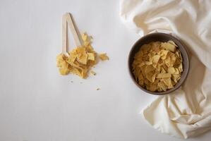 Potatoe chips and spoons on a white background photo
