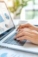 Engaging in data analysis and report creation using a laptop in a bright workspace with charts and graphs visible on the screen photo