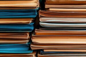 Stacked folders in various colors displaying organized chaos in an office environment during daytime photo