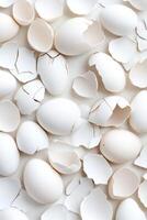 Cracked eggshells arranged in an abstract pattern on a white surface highlight modern food aesthetics with soft shadows and neutral tones photo