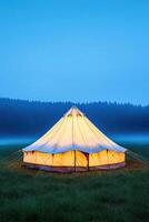 Abandoned carnival tent stands alone in a foggy field at night creating a mysterious and eerie atmosphere photo