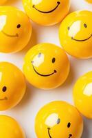 Creative arrangement of playful yellow smiley face balls in soft lighting on a minimalistic background photo