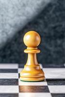 Philosophical chess concept exploring ambition through a lone pawn casting a kings shadow in deep symbolic lighting photo