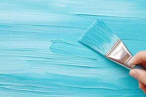 Close-up of a painter applying vibrant blue paint with a wide brush for smooth and professional finish in an artistic workspace photo