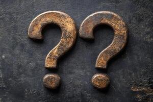 Rustic Question Marks on Textured Dark Surface - Symbol of Inquiry and Curiosity photo