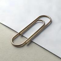 A golden paper clip on a white and beige paper, studio shot, product photography, clean and minimalist photo