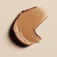 A rich, cocoa-toned foundation swatch with a dewy, lightweight formula. The smooth application and natural sheen highlight its hydrating properties, creating a soft, skin-like finish photo