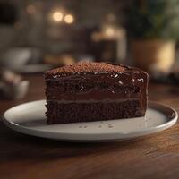 A slice of rich chocolate cake with a moist texture, layered with creamy chocolate ganache, and dusted with cocoa powder. Plated on a white dish, set against a cozy, blurred background photo
