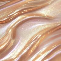 Glowing rose gold liquid highlighter swatch with a silky shimmer. The soft metallic texture catches the light, enhancing the skin with warm, reflective pink-gold hues and a radiant pearlescent finish photo