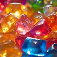 Shiny, irregularly shaped jelly candies in warm and cool tones. The translucent texture and reflections create a glowing, vibrant arrangement of sweets photo