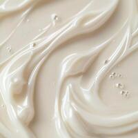 A creamy, smooth surface with flowing textures and soft curves. Subtle highlights and tiny bubbles add depth. Neutral, warm tones create a soothing visual effect photo