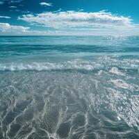 Sunlit beach with rolling waves reaching the shore. The open sea stretches to the horizon, creating a tranquil seaside ambiance with soft sand and the soothing rhythm of ocean tides photo
