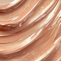 A rich brown liquid highlighter swatch with a metallic shimmer. The creamy texture blends seamlessly, reflecting warm bronze tones with fine iridescent particles for a luminous, radiant effect photo