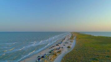 Sea sand spit with people camping, rest and relax on beach, view from above photo