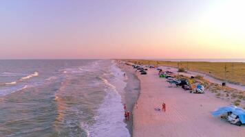 Campsite on sea spit, view above from drone, sunlight and people resting on beach photo