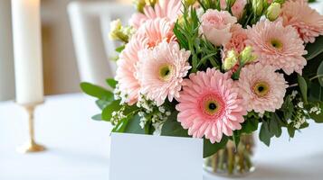 Beautiful Mother's Day table arrangement featuring pink gerberas and roses with delicate greenery and elegant candles photo