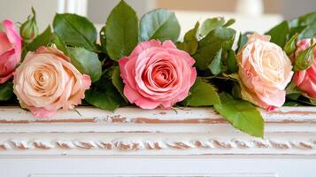 Close-up view of distressed whitewashed wood with a garland of beautiful roses showcasing soft pastel colors and vibrant greens photo