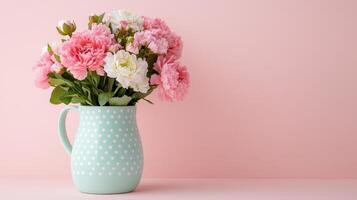 Delicate spring flowers arranged in a pastel polka dot pitcher against a soft pink background photo