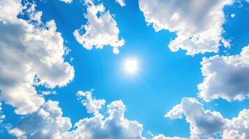 Bright blue spring sky with fluffy white clouds and radiant sunlight shining through photo