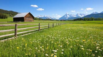 Rustic barn surrounded by vibrant flowers and mountains on a sunny day in the countryside photo