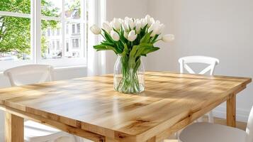 Serene dining space with a wooden table and fresh tulips in a bright airy room overlooking greenery photo