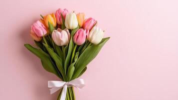 Elegant bundle of tulips tied with satin ribbon against a soft pink background photo