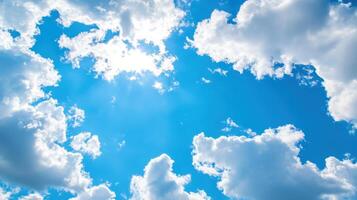 Bright spring sky adorned with soft clouds and vibrant blue hues under warm sunshine photo
