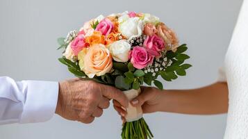 Elderly man presents bouquet of colorful roses to a woman in a softly lit indoor setting photo