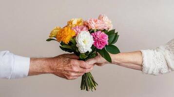 Elderly man gently handing a colorful bouquet of flowers to a woman in a warm setting photo