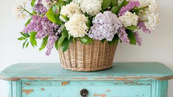 Old wooden table with peeling paint showcasing a vibrant floral arrangement in a woven basket photo