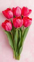 Pink tulips arranged beautifully in a bouquet against a soft pastel background photo