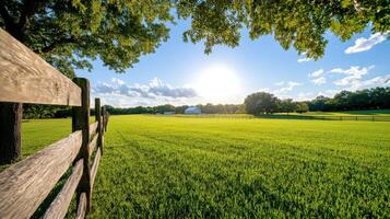 Golden sunlight filters through fields revealing vibrant greenery near a rustic fence on a serene afternoon photo