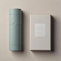 A cylinder in light blue is next to a rectangular box in white. Both are open on a beige surface. photo