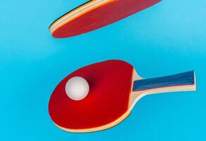 Red ping pong racket on a blue background photo