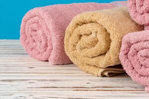 Stack of rolled towels on a wooden table photo