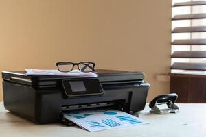 Front view of a black printer machine on a table photo