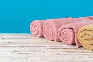 Stack of rolled towels on a wooden table photo