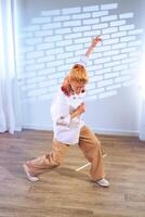 Dancer showcases expressive movement in a bright indoor space with shadow patterns on the wall photo