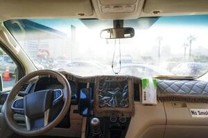 Interior view of a parked vehicle showing dashboard and surrounding environment on a sunny day photo