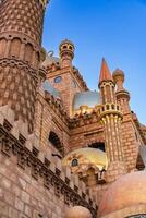 Stunning architectural details of an ornate castle in a clear blue sky, showcasing intricate designs and unique domes photo