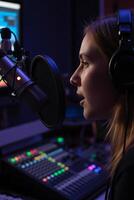 A close-up portrait of a radio host, with blond hair wearing headphones, speaking into a professional microphone in a dimly lit recording studio photo