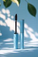 Elegant blue mascara tube with black applicator displayed against a soft background illuminated by natural light photo